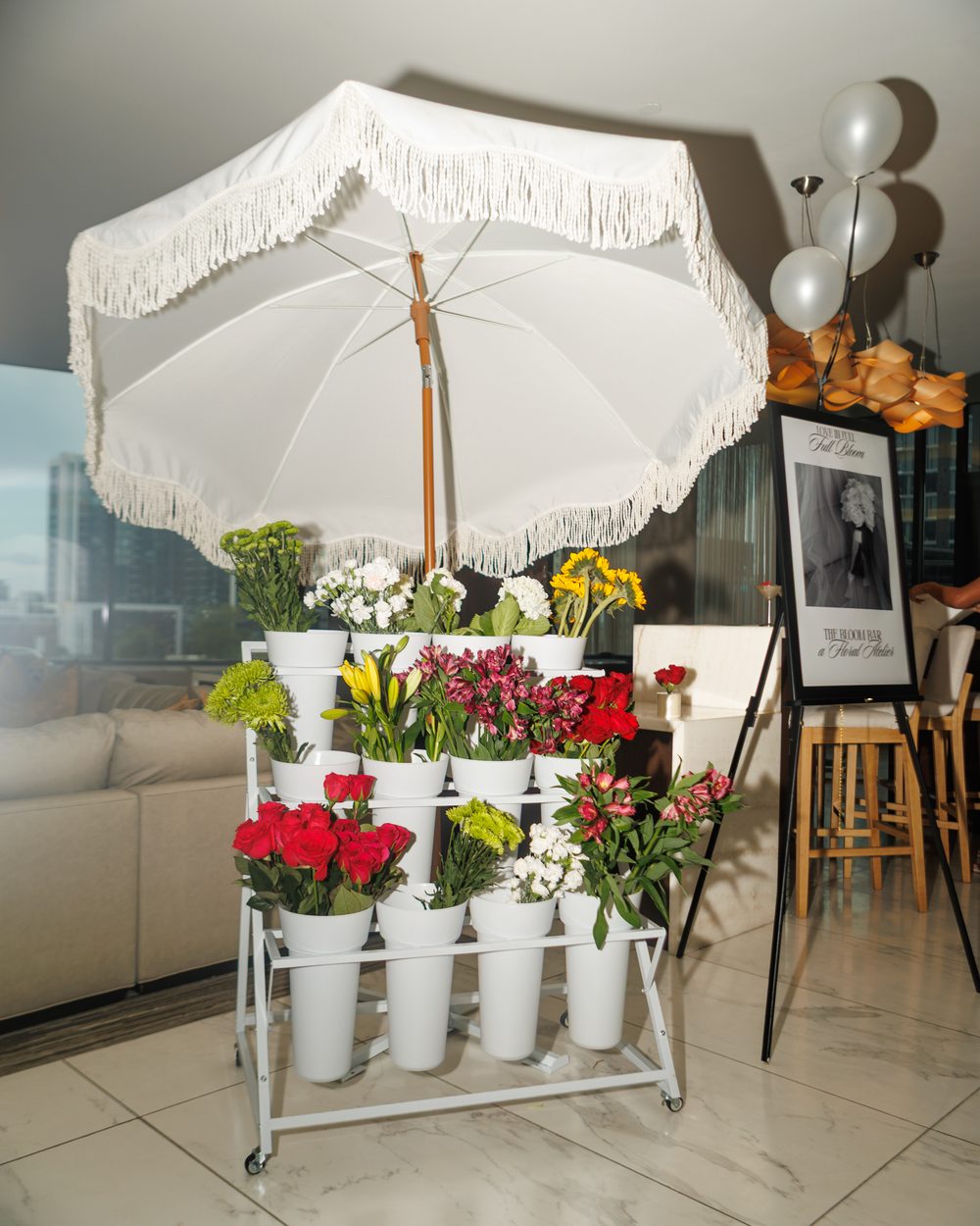 Floral cart and fringed umbrella styled for a surprise bridesmaids dinner